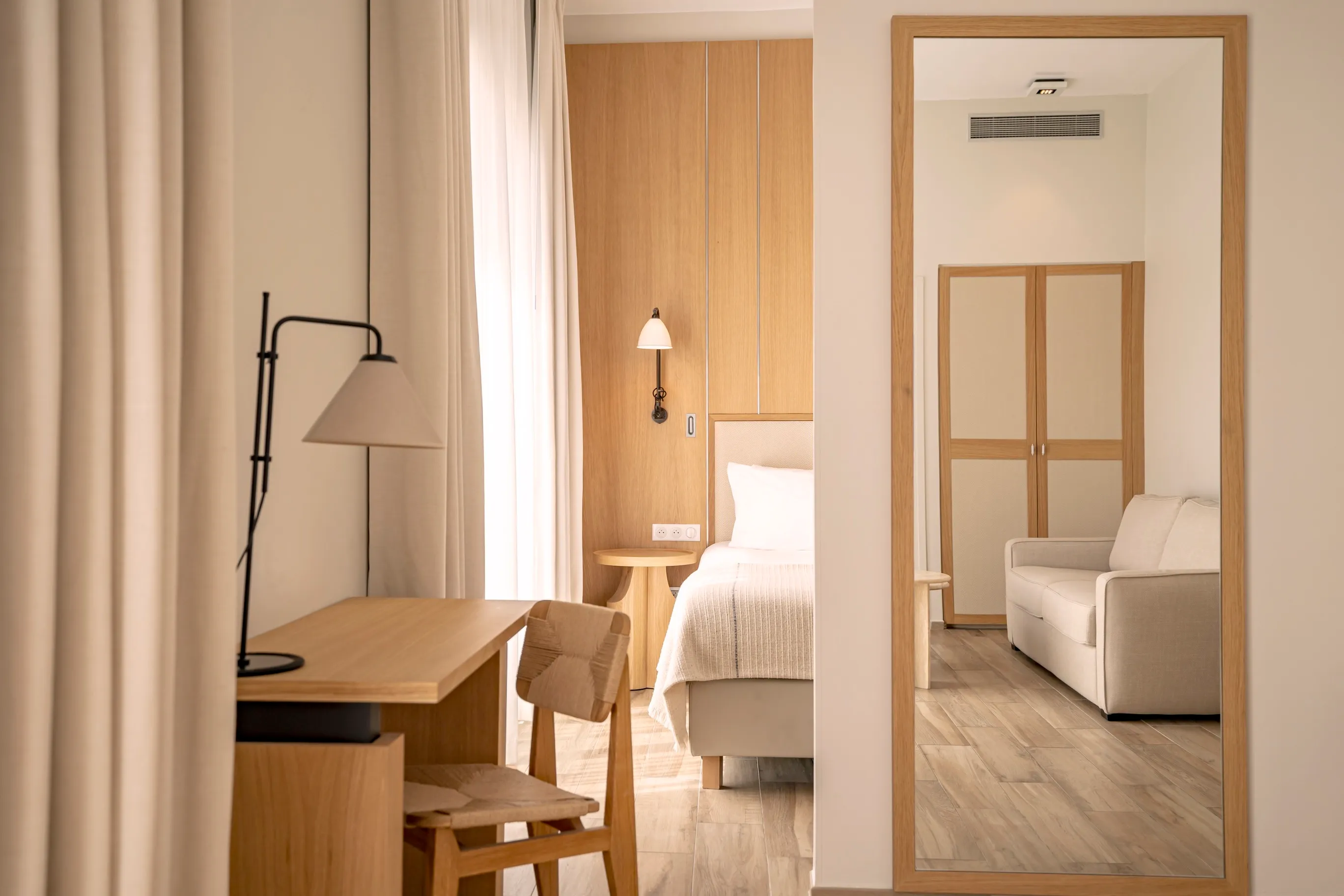 Espace bureau élégant avec miroir de plein pied et mobilier sur-mesure dans une suite Prestige lumineuse.