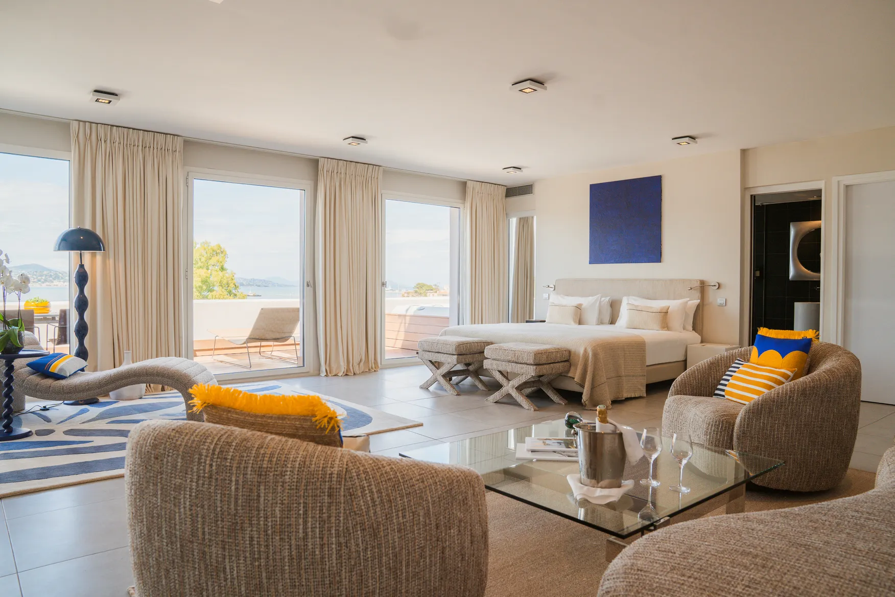 Suite de luxe spacieuse à l'Hôtel Kube Saint-Tropez : salon design, lit King Size et terrasse privée vue mer.