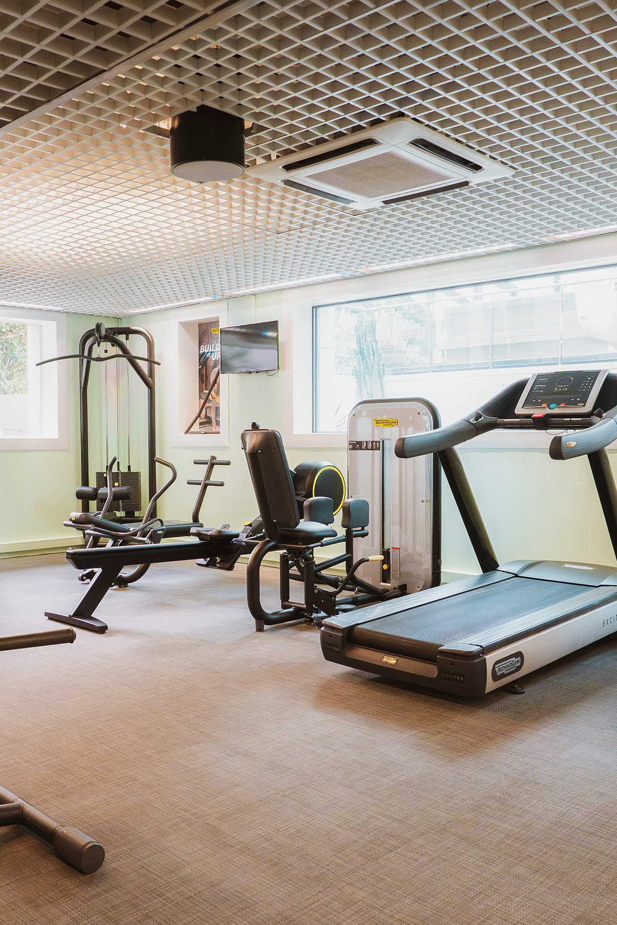 Espace bien-être et entraînement sportif de l'Hôtel Kube Saint-Tropez, incluant banc de musculation et appareils cardio.
