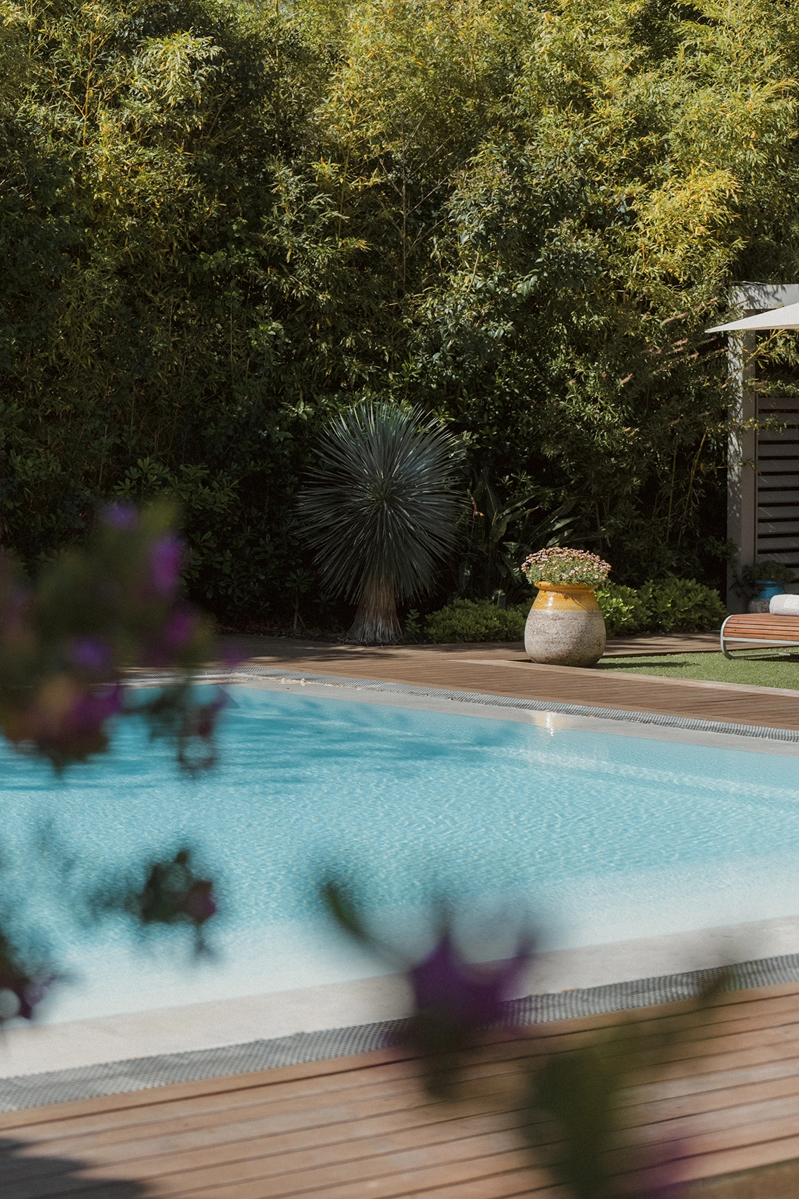 Grande piscine extérieure de luxe entourée de transats et parasols blancs à l'Hôtel Kube Saint-Tropez.