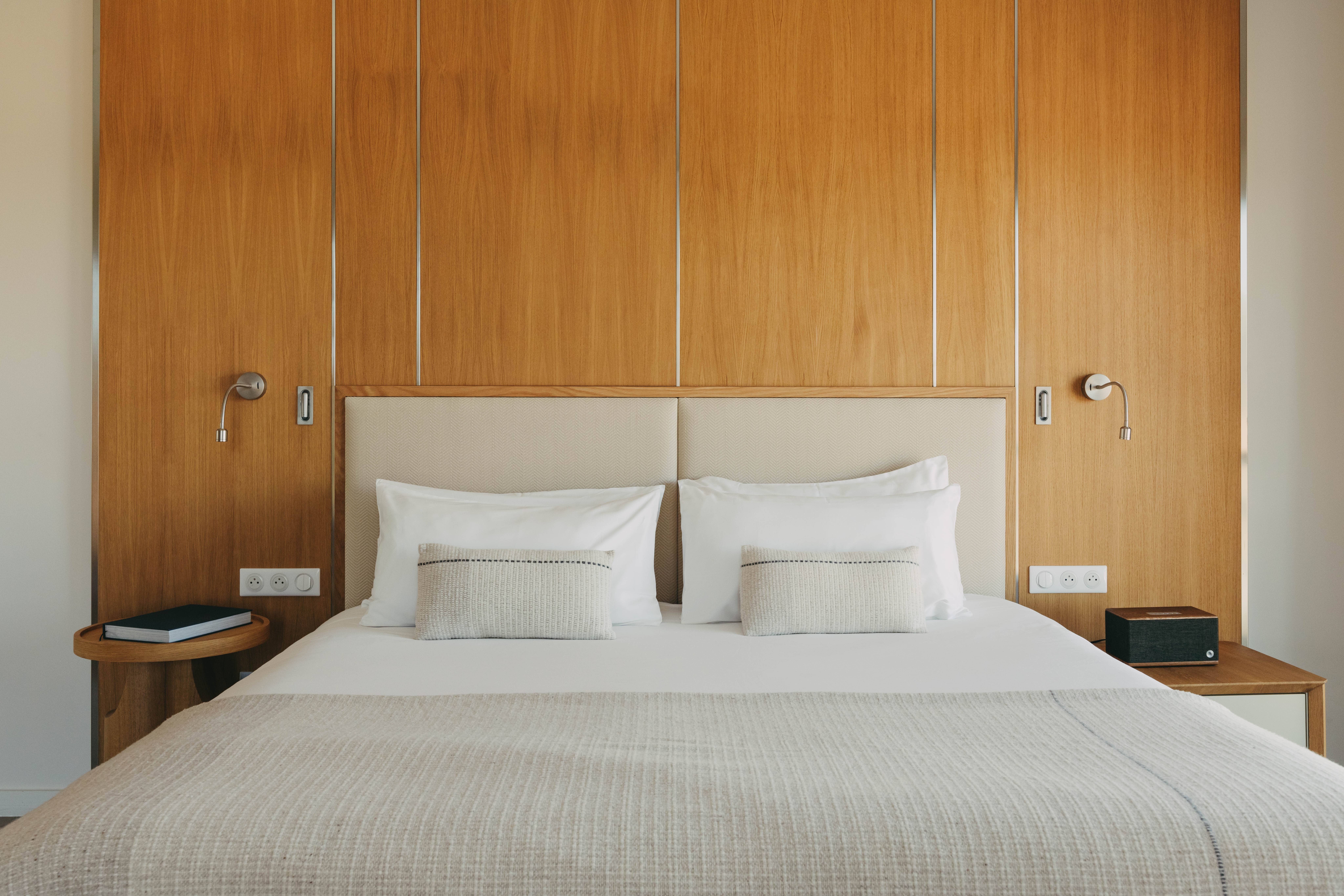 Lit King-size avec linge de lit premium, Chambre Junior Natural Sea, Kube Saint Tropez, confort et luxe moderne.