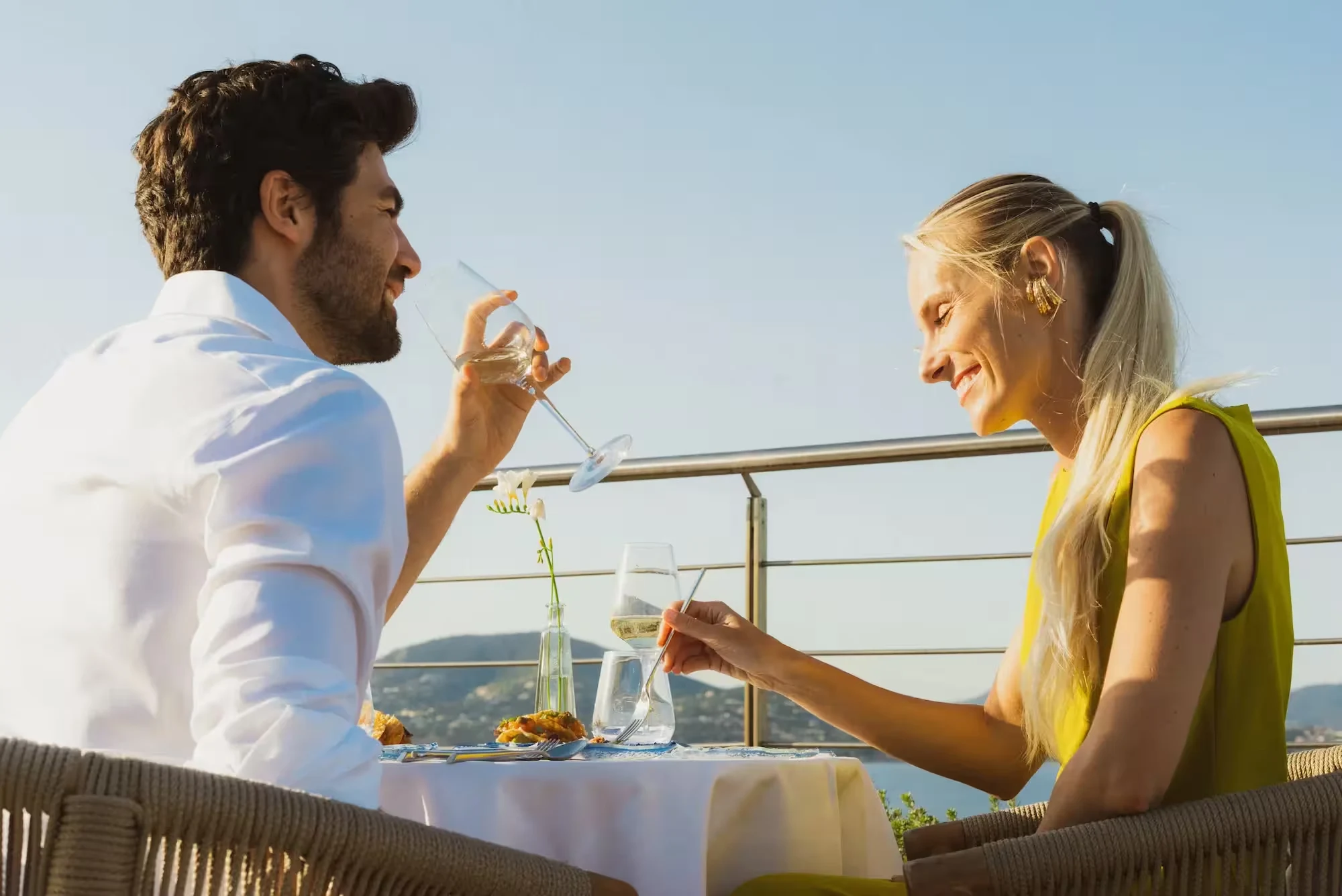 Couple trinquant en terrasse face au golfe de Saint-Tropez